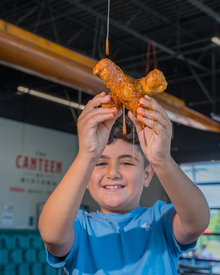 A kid pulling cheese from a mozzarella brick